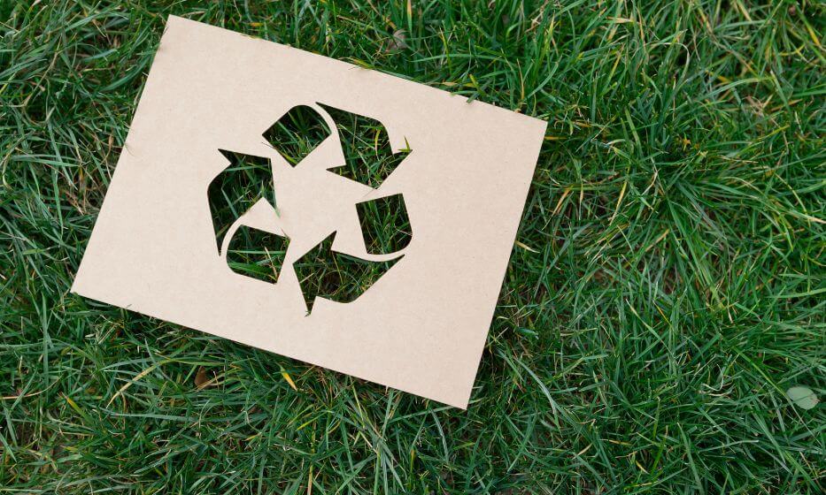 Znak ekologii i recyklingu na tle zielonej trawy